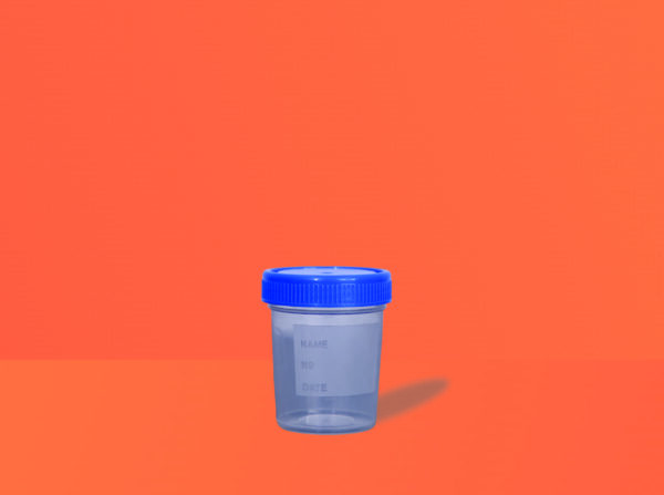 Urine container by Mono Industries placed on a table. Available in sizes 30ml, 50ml and 100ml